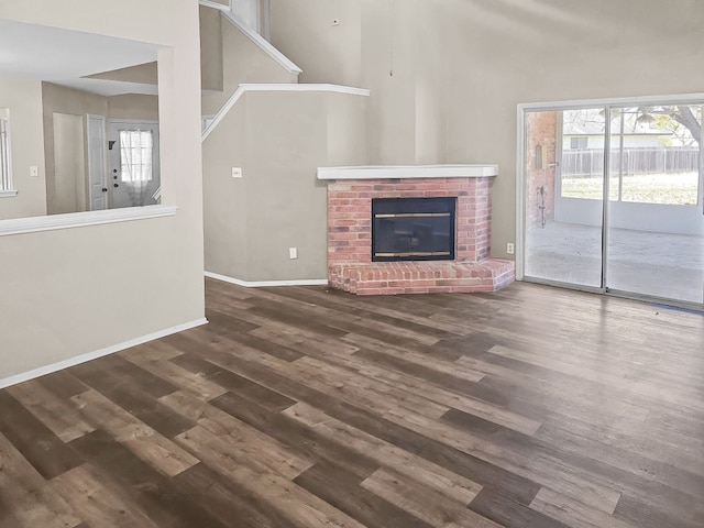 unfurnished living room featuring a fireplace and dark hardwood / wood-style floors