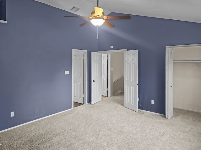 unfurnished bedroom with light carpet, a closet, high vaulted ceiling, and ceiling fan