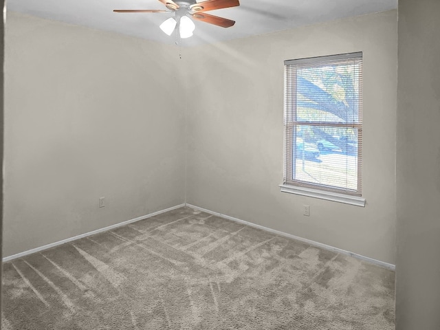 carpeted spare room with ceiling fan