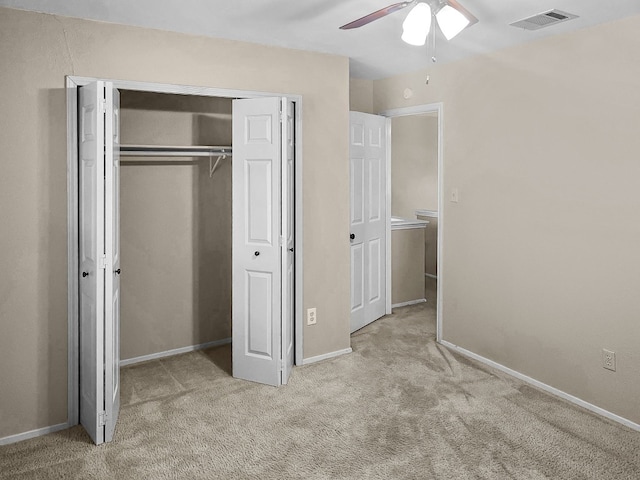 unfurnished bedroom with light carpet, a closet, and ceiling fan