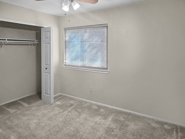 unfurnished bedroom with ceiling fan, a closet, and light colored carpet