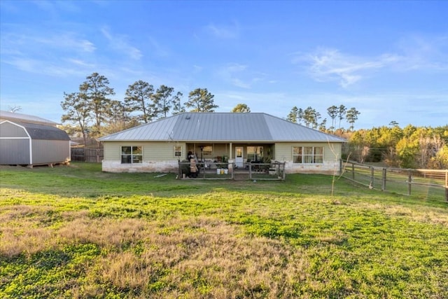 rear view of property with a yard and a shed