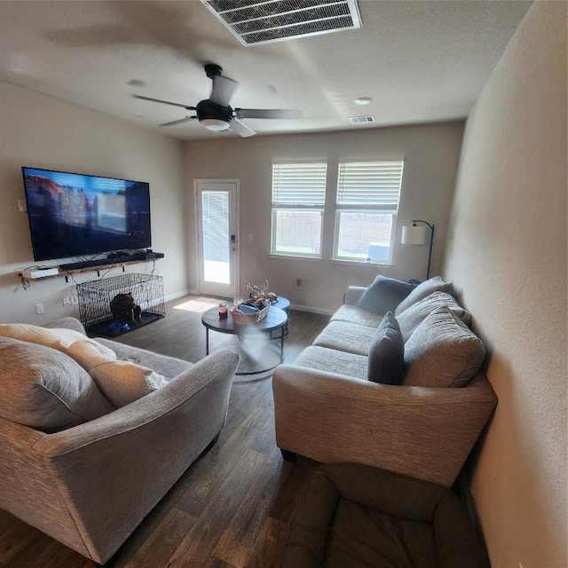 living room featuring ceiling fan and dark hardwood / wood-style flooring