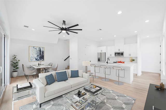 living room with ceiling fan and light wood-type flooring