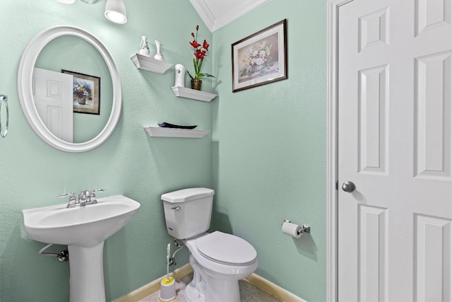 bathroom featuring toilet, crown molding, and sink