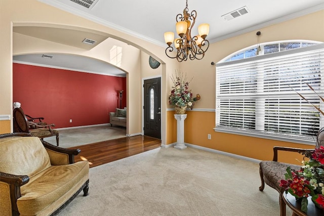 sitting room featuring carpet flooring, a chandelier, and crown molding