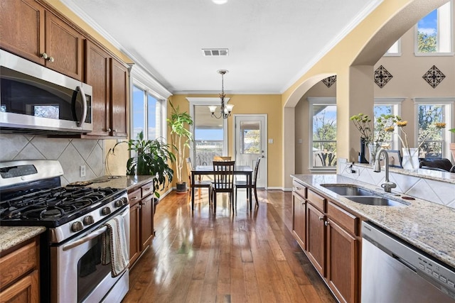 kitchen with sink, stainless steel appliances, plenty of natural light, and a notable chandelier