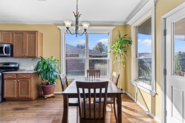 dining room with plenty of natural light, wood-type flooring, and a chandelier