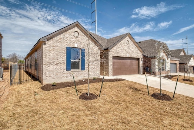 view of front of house with concrete driveway, an attached garage, fence, central AC, and brick siding