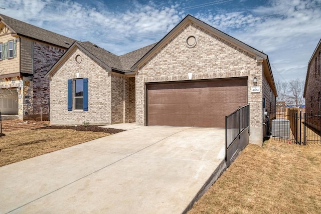 view of front facade featuring a garage, driveway, fence, and brick siding