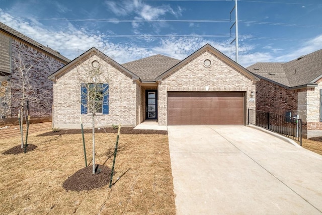 view of front of house with driveway, brick siding, roof with shingles, and an attached garage