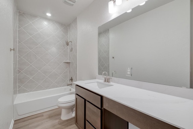 bathroom featuring shower / tub combination, toilet, wood finished floors, visible vents, and vanity