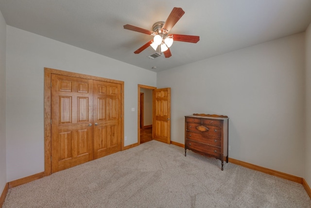 unfurnished bedroom with ceiling fan, a closet, and light carpet