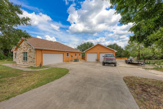 single story home featuring an outbuilding, a garage, and a front yard