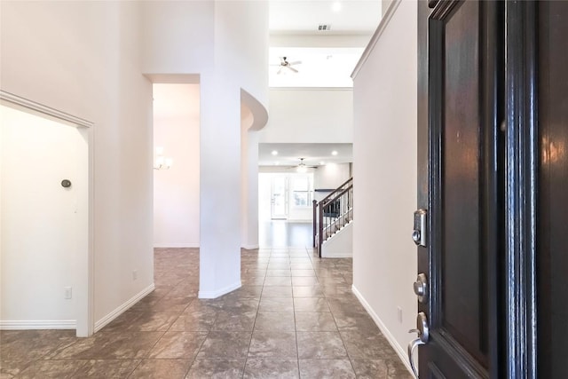 entryway with ceiling fan and a high ceiling