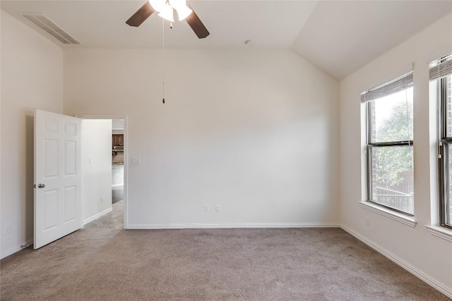 carpeted spare room with lofted ceiling, ceiling fan, and a wealth of natural light