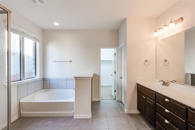 bathroom featuring a bathing tub, tile patterned flooring, and vanity