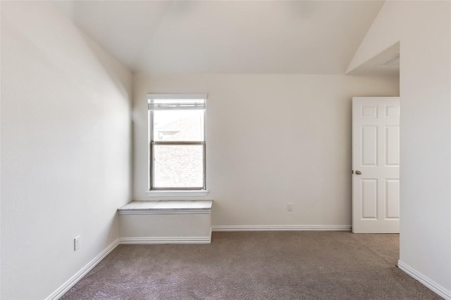 carpeted empty room featuring lofted ceiling