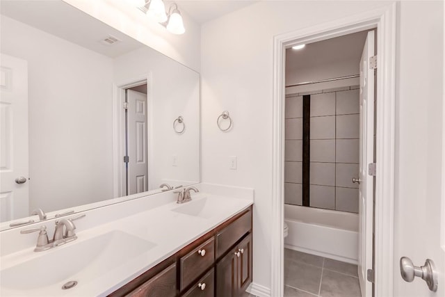 full bathroom with tiled shower / bath combo, tile patterned floors, vanity, and toilet