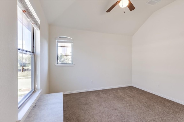 carpeted spare room featuring ceiling fan, a healthy amount of sunlight, and vaulted ceiling