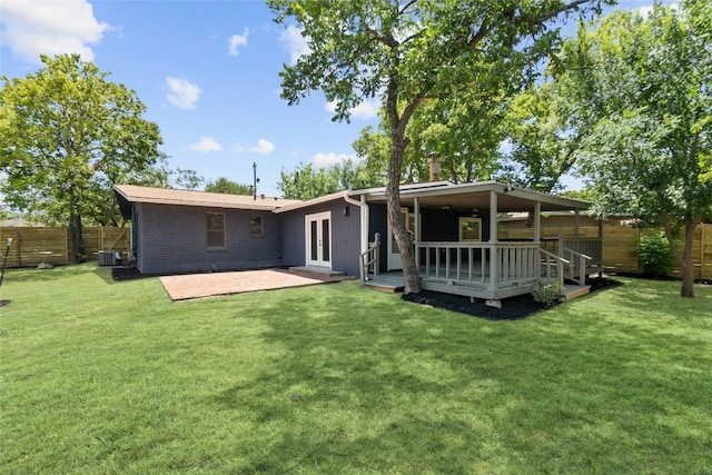 back of house featuring a lawn, a wooden deck, and french doors