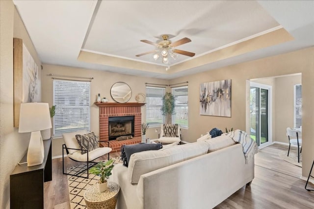 living room with hardwood / wood-style flooring, a raised ceiling, and a wealth of natural light