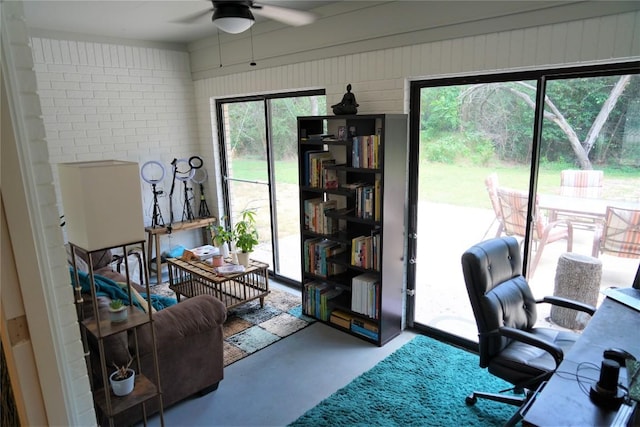 home office featuring ceiling fan and concrete flooring