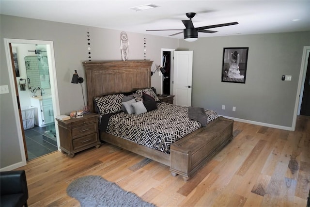 bedroom featuring connected bathroom, light hardwood / wood-style flooring, and ceiling fan