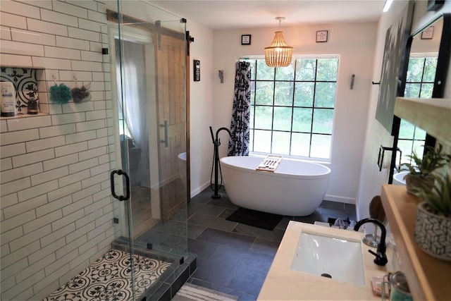 bathroom with tile patterned floors, separate shower and tub, vanity, and a chandelier