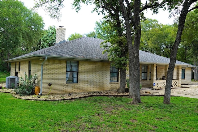 view of side of home with central air condition unit and a lawn