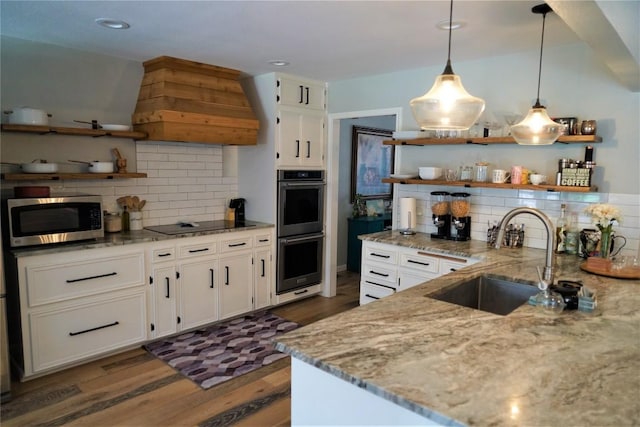 kitchen featuring appliances with stainless steel finishes, sink, pendant lighting, dark hardwood / wood-style floors, and white cabinetry