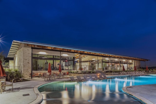 pool at night with a patio area