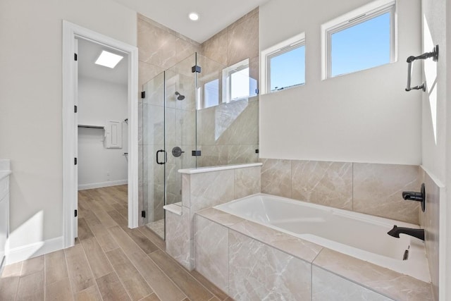 bathroom featuring plus walk in shower and hardwood / wood-style flooring