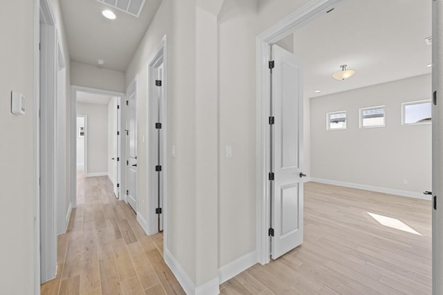 corridor with light hardwood / wood-style floors