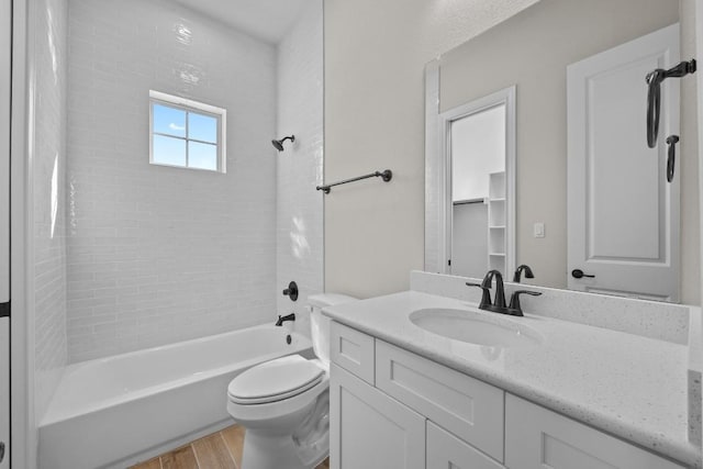 full bathroom with wood-type flooring, vanity, toilet, and tiled shower / bath combo