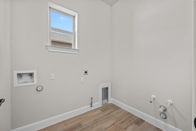 clothes washing area featuring hookup for a gas dryer, light hardwood / wood-style flooring, washer hookup, and hookup for an electric dryer