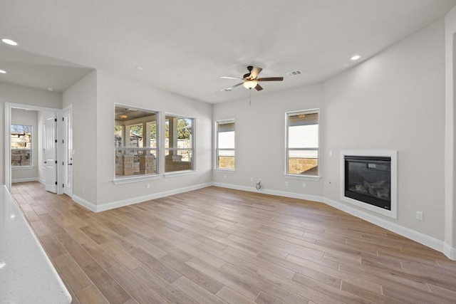 unfurnished living room featuring ceiling fan and light hardwood / wood-style floors