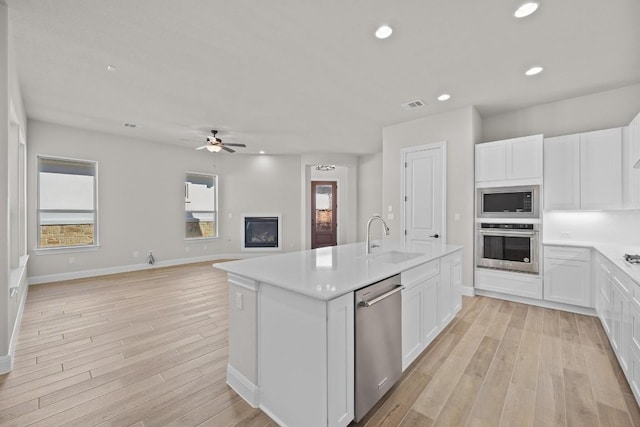 kitchen featuring white cabinets, sink, stainless steel appliances, and a wealth of natural light