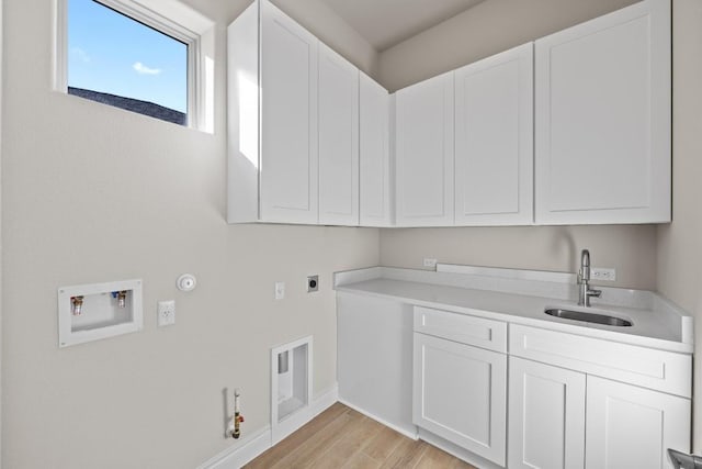 laundry room with cabinets, hookup for a gas dryer, sink, light hardwood / wood-style flooring, and washer hookup