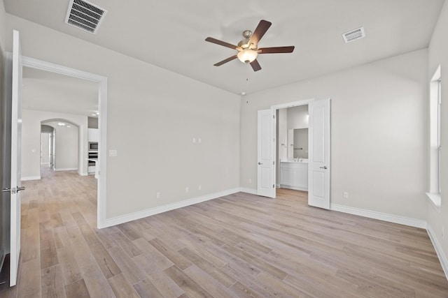 unfurnished bedroom with ensuite bathroom, light hardwood / wood-style flooring, and ceiling fan