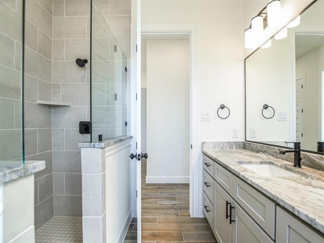 bathroom with a tile shower and vanity