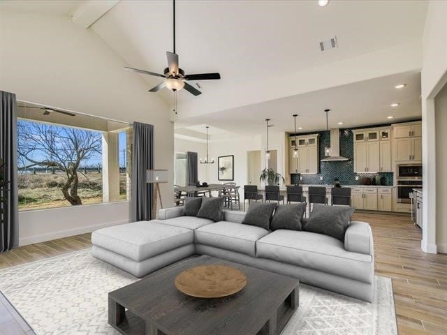 living room featuring ceiling fan, light hardwood / wood-style flooring, and lofted ceiling with beams