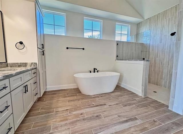 bathroom with vanity, separate shower and tub, and lofted ceiling