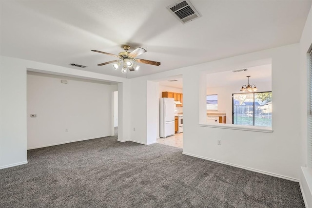 empty room with carpet and ceiling fan with notable chandelier