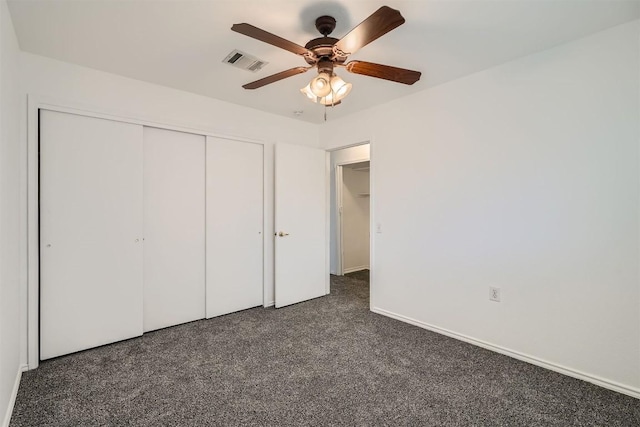 unfurnished bedroom with ceiling fan, a closet, and dark colored carpet