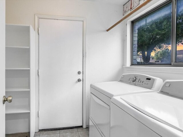 laundry room with washer and dryer and light tile patterned floors