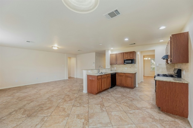 kitchen with black appliances, kitchen peninsula, sink, and tasteful backsplash