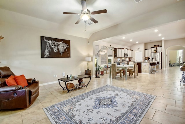 tiled living room featuring ceiling fan and vaulted ceiling