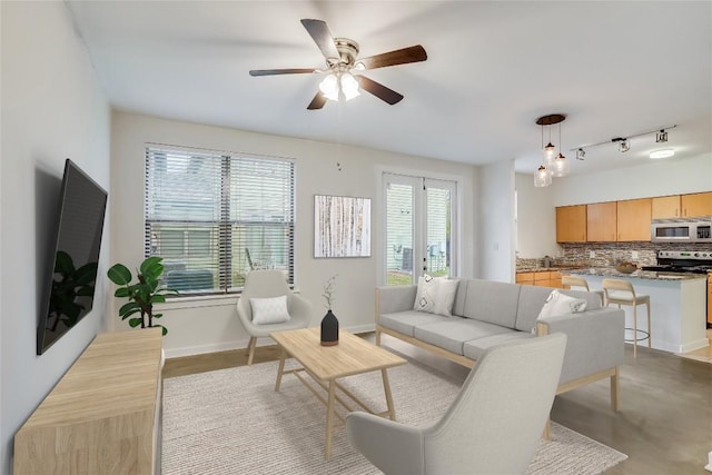 living room featuring ceiling fan and a wealth of natural light