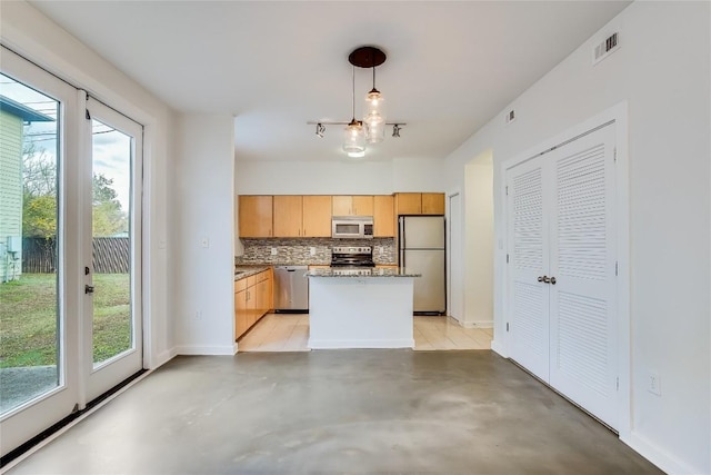 kitchen featuring pendant lighting, tasteful backsplash, light brown cabinetry, appliances with stainless steel finishes, and a kitchen island